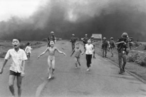 South Vietnamese forces follow after terrified children, including 9-year-old  Kim Phuc, center, as they run down Route 1 near Trang Bang after an aerial napalm attack on suspected Viet Cong hiding places, June 8, 1972.  A South Vietnamese plane accidentally dropped its flaming napalm on South Vietnamese troops and civilians. The terrified girl had ripped off her burning clothes while fleeing. The children from left to right are: Phan Thanh Tam, younger brother of Kim Phuc, who lost an eye, Phan Thanh Phouc, youngest brother of Kim Phuc, Kim Phuc, and Kim's cousins Ho Van Bon, and Ho Thi Ting.  Behind them are soldiers of the Vietnam Army 25th Division. (AP Photo/Nick Ut)