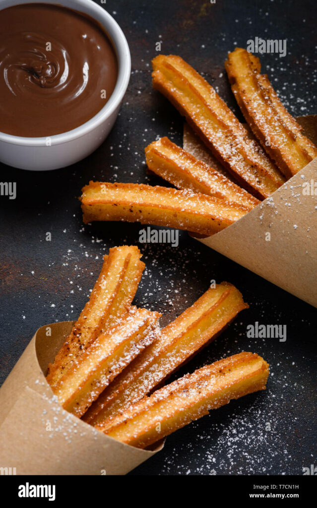 Churros with sugar cinnamon and chocolate sauce dip on dark background  Stock Photo - Alamy